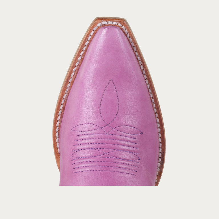 Close-up of a pink leather boot with brown trim on a light gray background